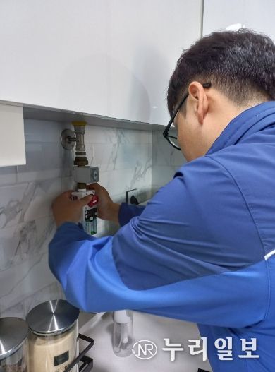 치매·홀몸 어르신 가구에 가스타이머 콕을 설치하고 있는 모습.