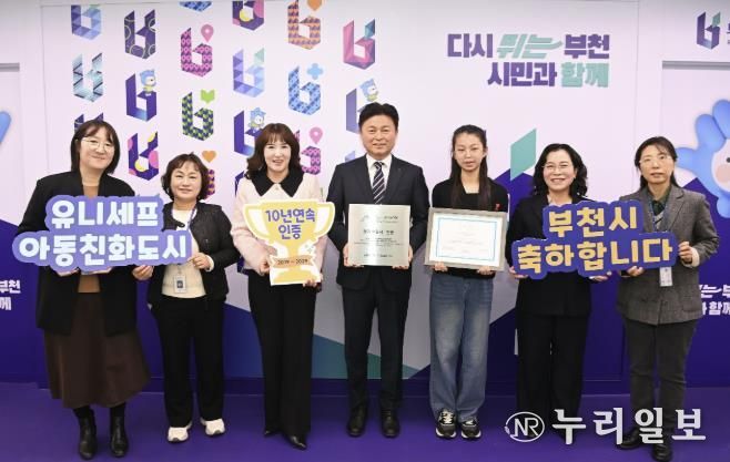 조용익 부천시장과(오른쪽 네 번째), 허정원 아동친화도시조성 추진위원회 부위원장(오른쪽 다섯 번째), 이서현 아동참여위원회 위원장(오른쪽에서 세 번째), 정애경 복지국장(오른쪽 두 번째), 아동보육과 직원들이 유니세프 아동친화도시 인증 기념사진을 찍고 있다.