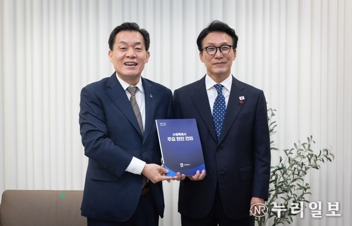 이재준 수원시장(왼쪽)이 김민석 국무총리에게 건의문을 전달한 후 기념촬영을 하고 있다.