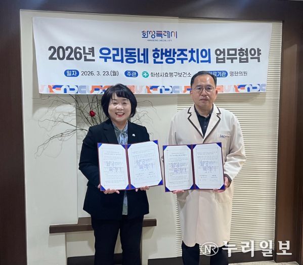 유종우 효행구보건소장과 명한의원 윤탁현 원장이 업무협약을 체결하고 협약서를 들고 기념촬영을 하고 있다